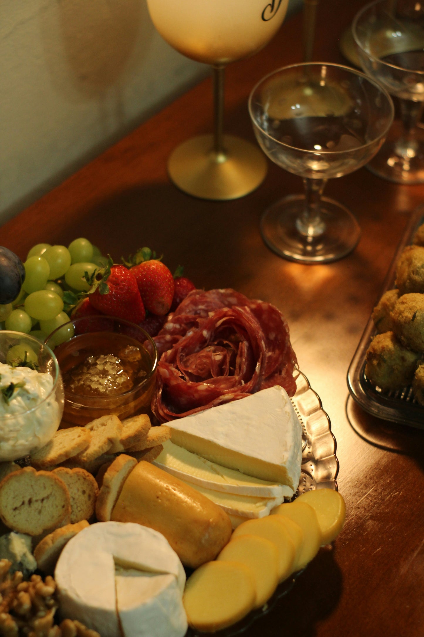 Candlelit charcuterie board with cheese, fruit and wine at a Midlife Blush midweek retreat welcome evening
