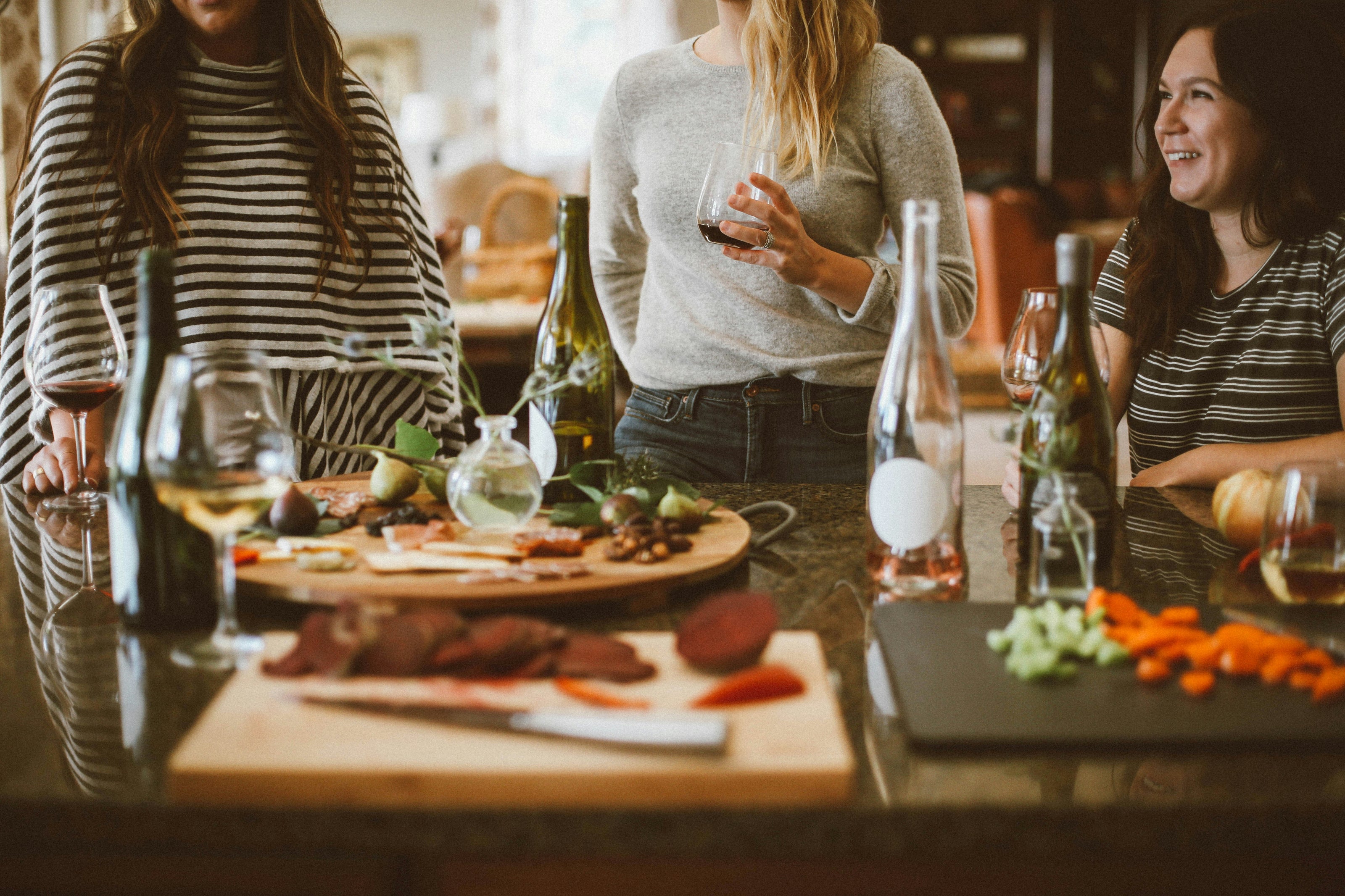Women enjoying a charcuterie board, wine and nibbles on the first evening of a Midlife Blush retreat

